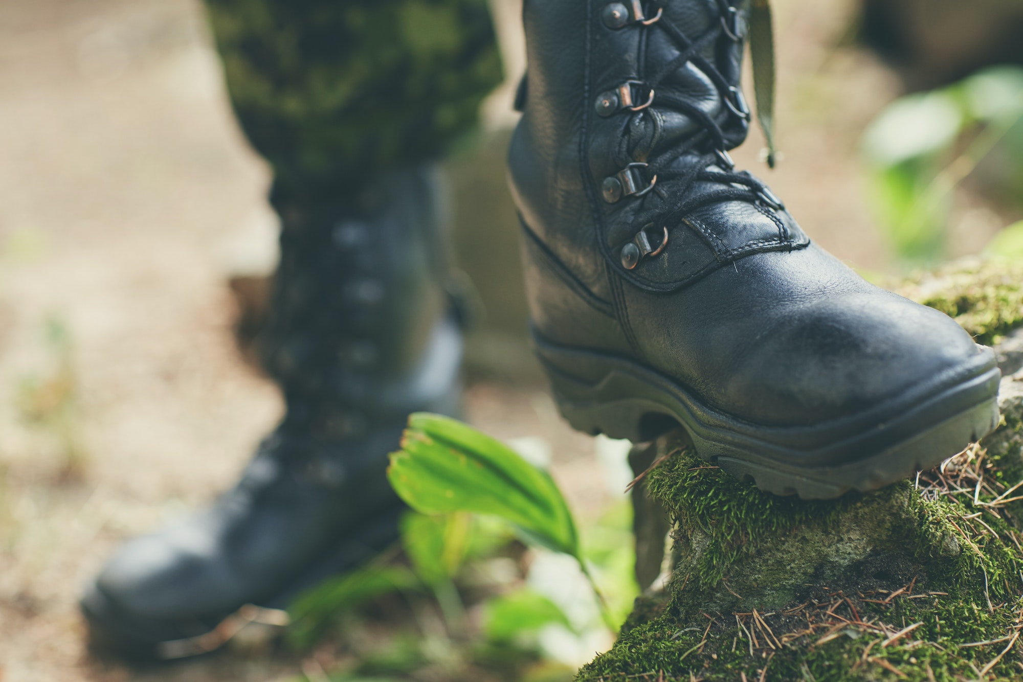 close up of soldier feet with army boots in forest